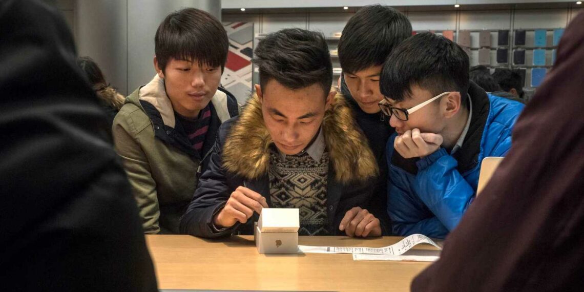 FILE Ñ A man sets up his new iPhone 6s as friends look on at an Apple store in Beijing, Dec. 19, 2015. The technology giant announced that revenue for its second fiscal quarter, which ended in March, fell 13 percent to $50.6 billion as sales of its flagship product, the iPhone, fell, with little else to take its place. (Gilles Sabrie/The New York Times)