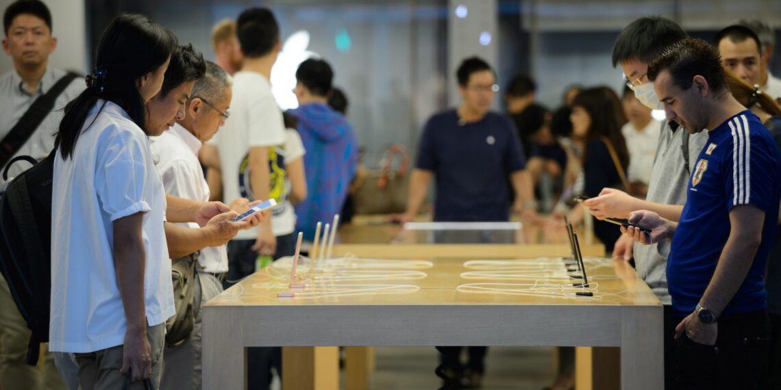 Shoppers try out Apple Inc. iPhone 7 smartphones at the company's store in the Ginza district of Tokyo, Japan, on Tuesday, Sept. 27, 2016. The Japanese currency has gained 19 percent against the U.S. dollar this year, undermining the Bank of Japan's efforts to stoke inflation and economic growth. Photographer: Akio Kon/Bloomberg